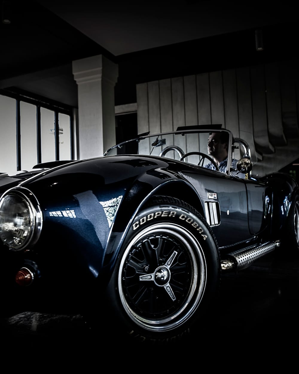 Olivier Chadebost au volant d'une Cobra noire, dans la pénombre