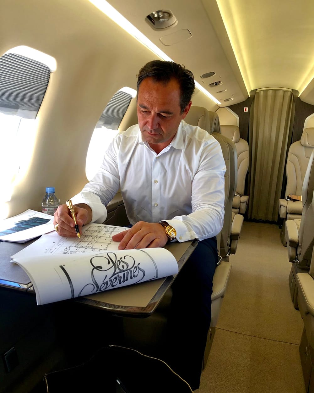 Olivier Chadebost dessinant à la main un projet, en avion