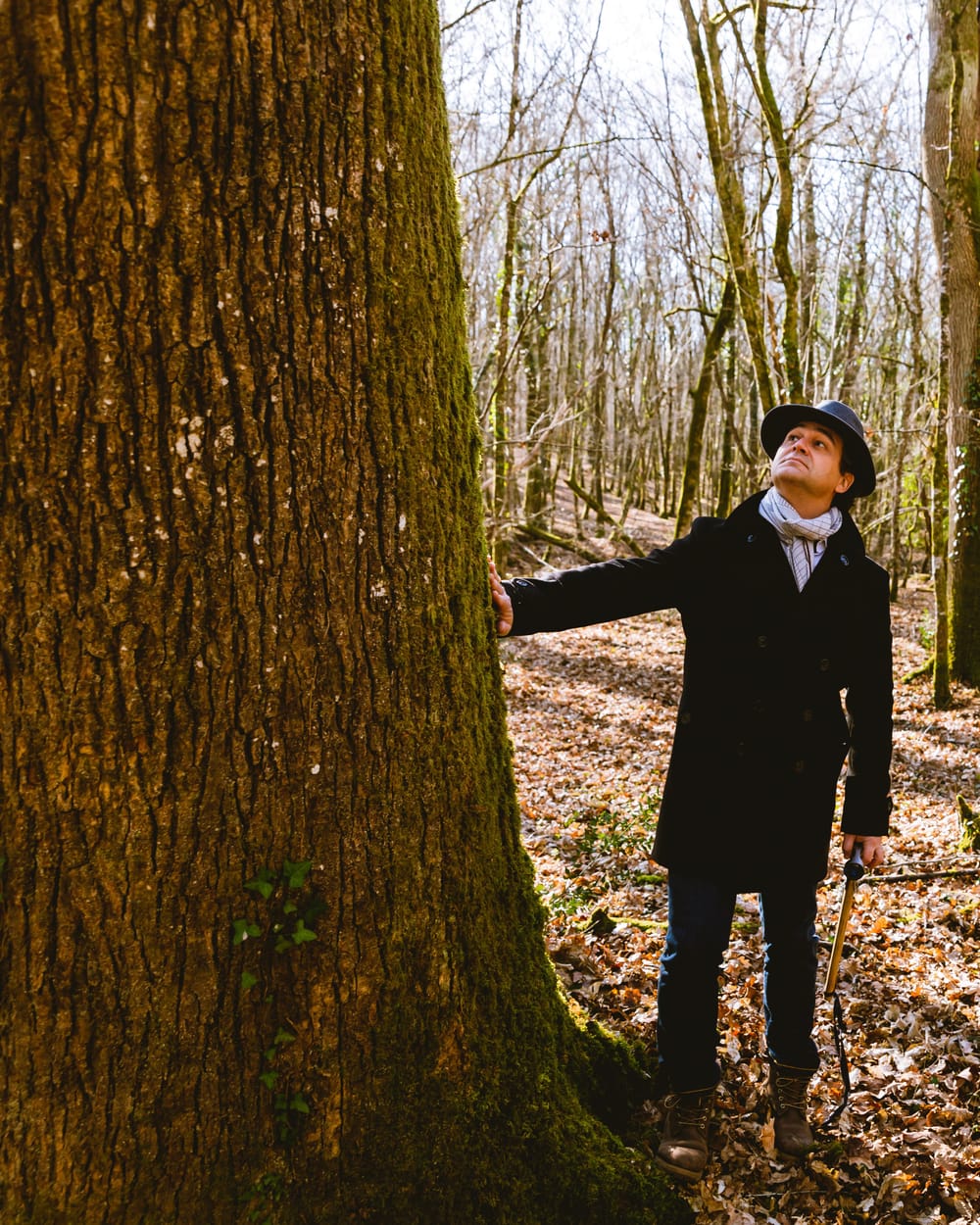 Olivier Chadebost en forêt, la main sur un chêne