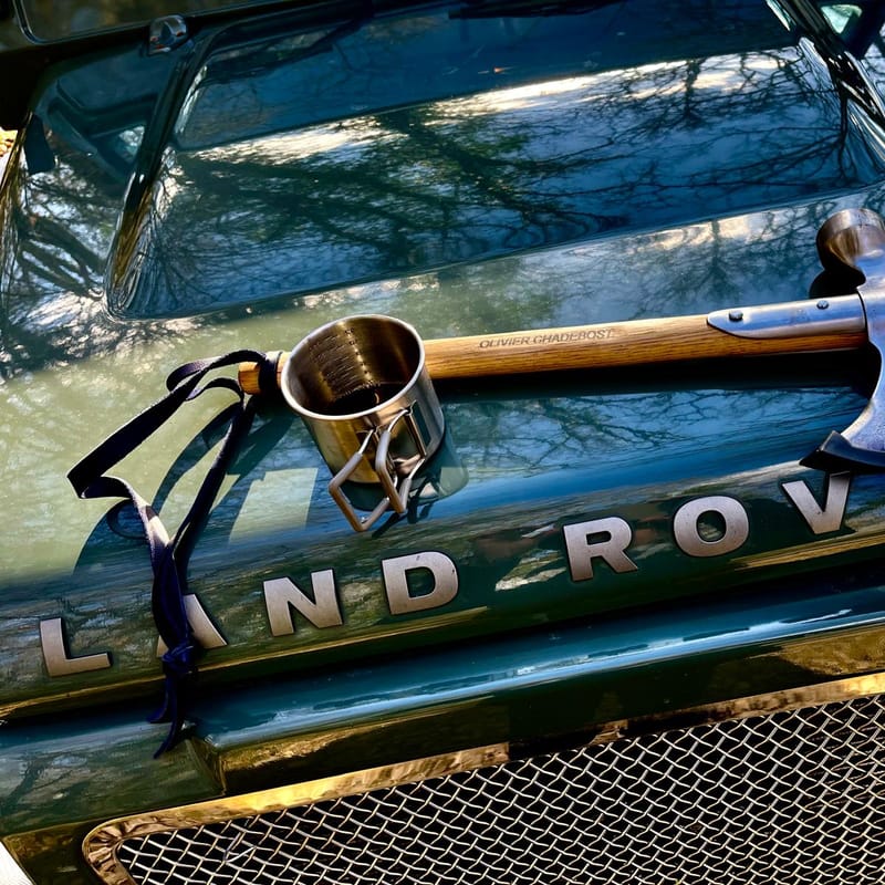 Axe and metal mug on the bonnet of a Land Rover