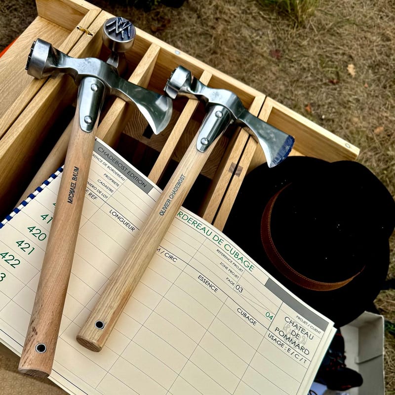 Two forestry hammers on a Château de Pommard timber tally sheet