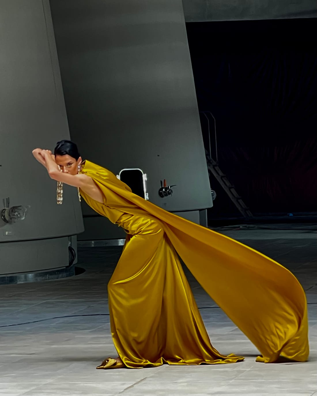 Danseuse en robe dorée entre les cuves d'un chai