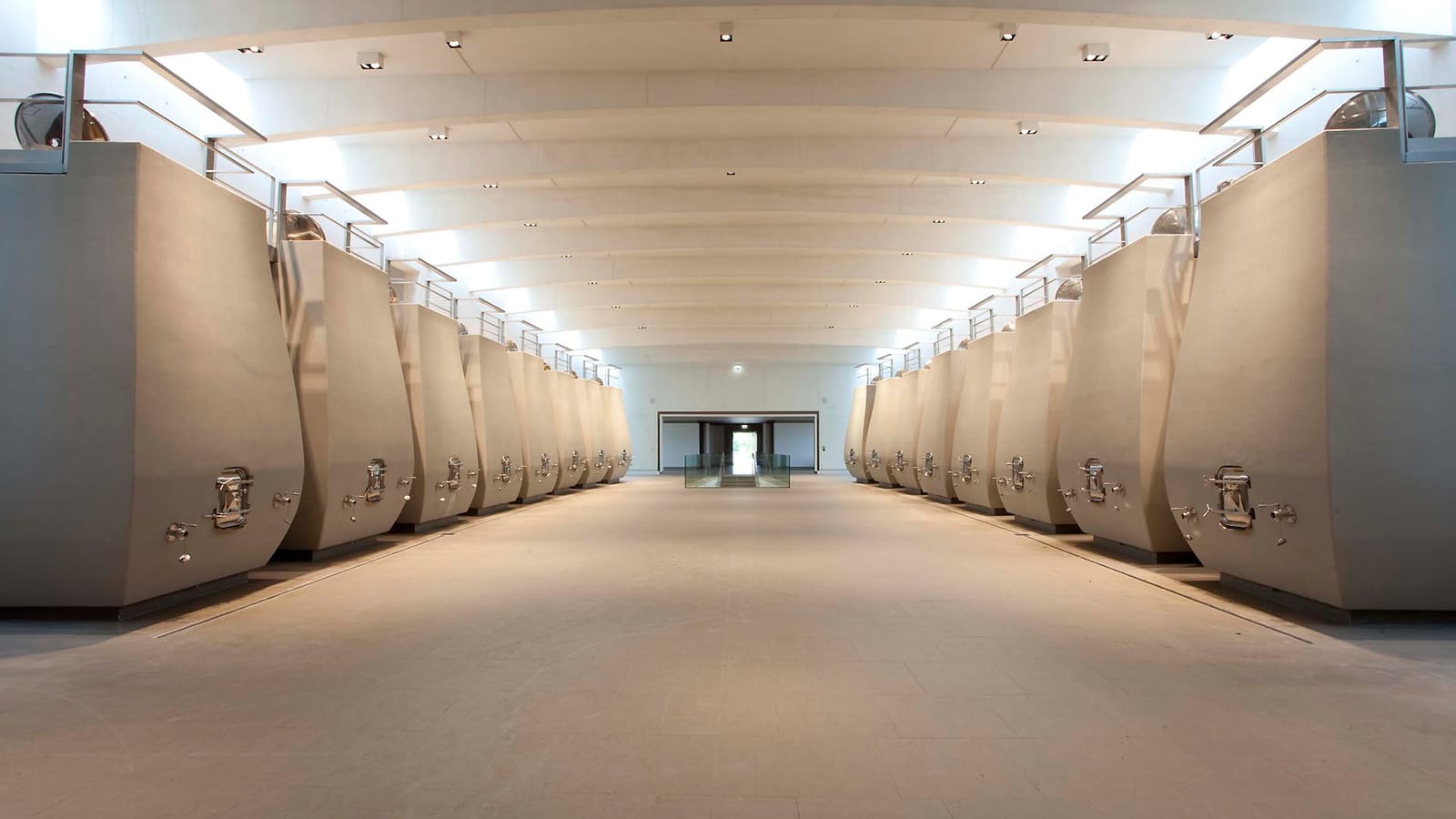 Alignement symétrique de cuves en béton incurvées dans un chai moderne et lumineux, Château Cheval Blanc à Saint-Émilion