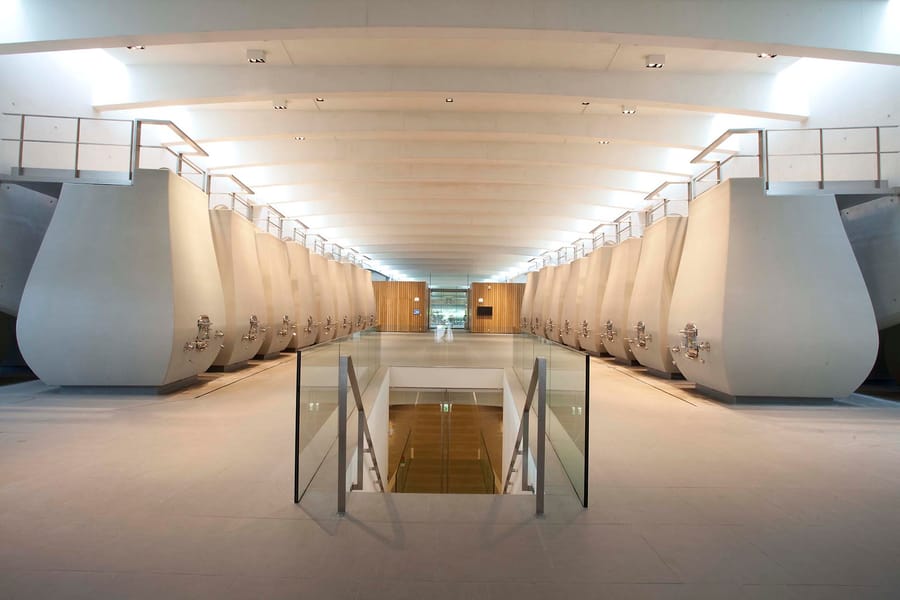 Grand cuvier contemporain aux cuves en béton alignées sous un plafond voûté dans un domaine viticole, Château Cheval Blanc à Saint-Émilion