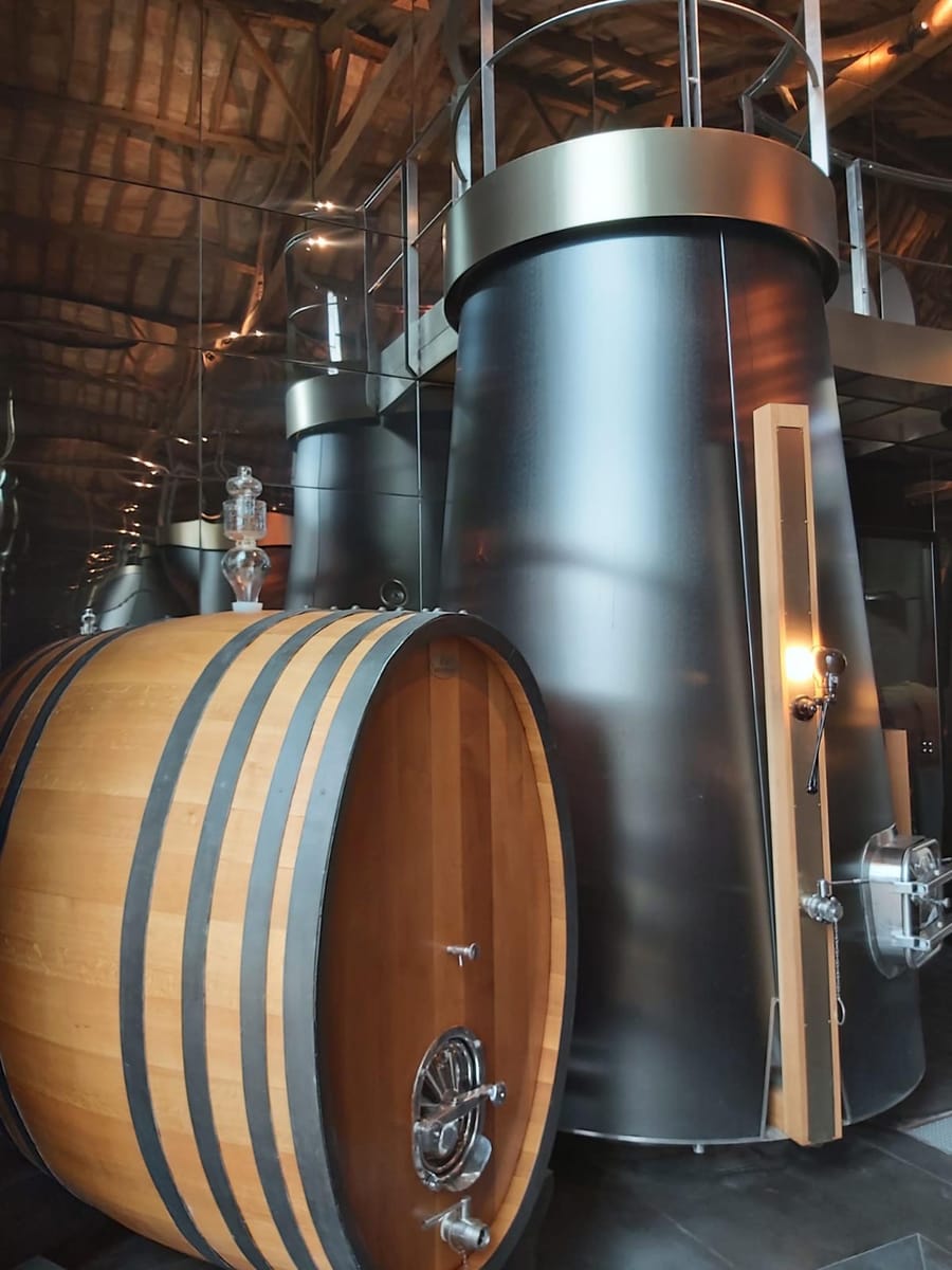 Grand foudre en bois et cuve métallique moderne aménagés dans un chai contemporain à La Gaude