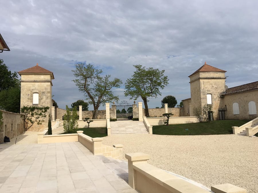 Cour d'honneur restaurée en pierre claire avec escalier central et tourelles au château de Sours