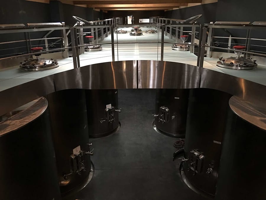 Cuves en acier inoxydable et passerelle métallique au cœur d'un chai viticole moderne, Château Lafon-Rochet à Saint-Estèphe