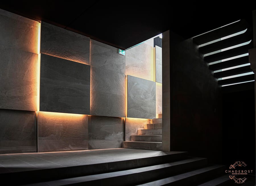 Escalier et mur en dalles de pierre rétroéclairées au design intérieur contemporain, conçus par Chadebost à Montlabert