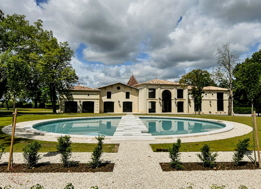 Façade d'une propriété restaurée bordée d'un bassin circulaire et d'un jardin paysager, projet d'architecture, Château Montlabert à Saint-Émilion