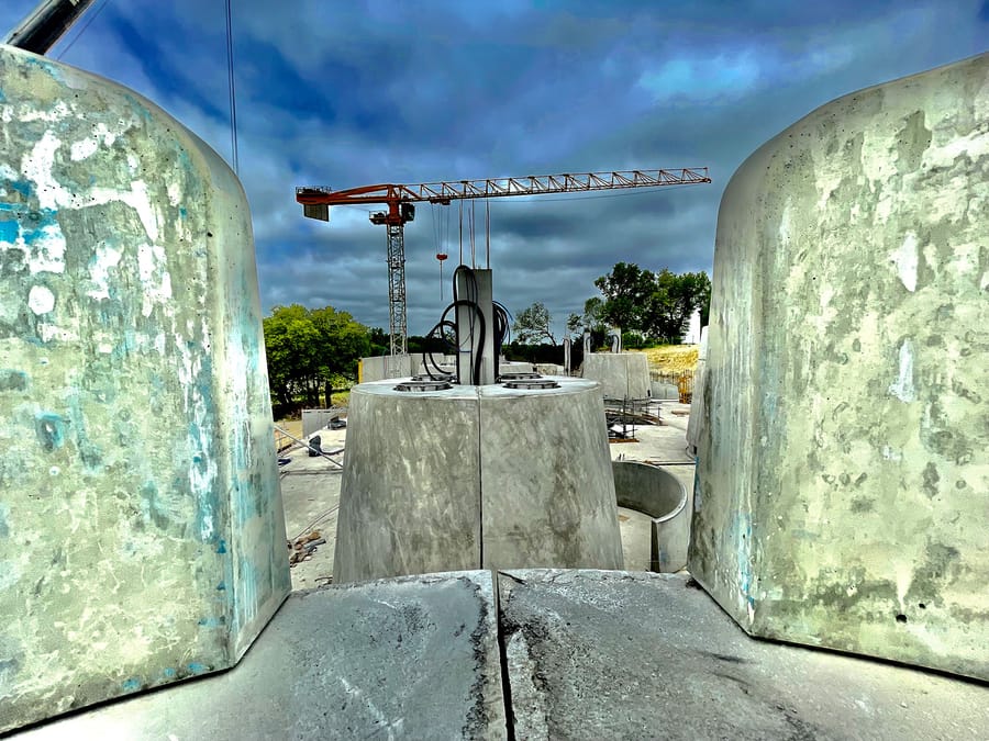 Modules en béton et grue rouge s'élevant sur un chantier de construction, Château Plain Point à Fronsac