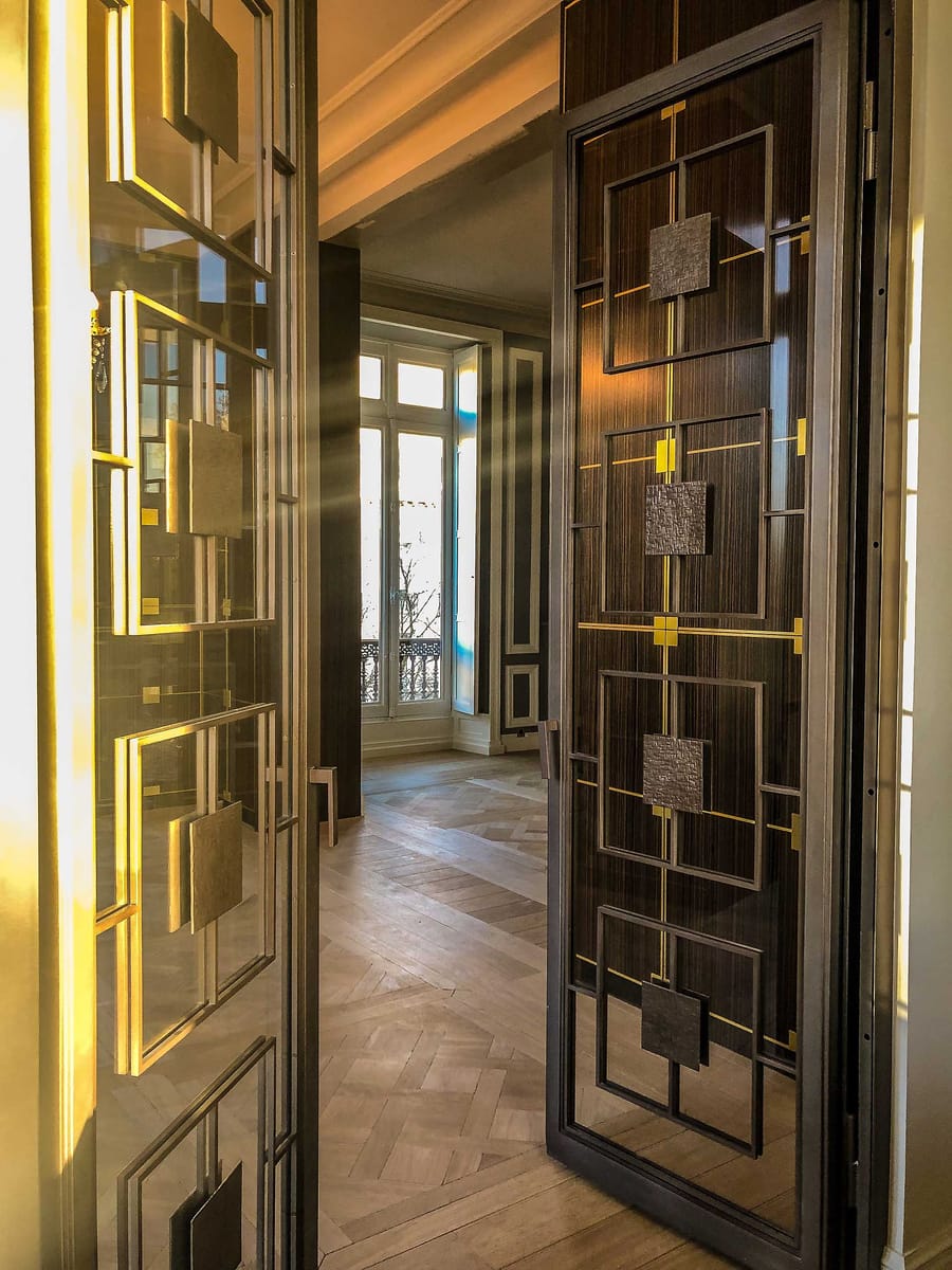 Porte sur mesure aux motifs géométriques dorés ouvrant sur une pièce lumineuse avec parquet en bois, à Bordeaux