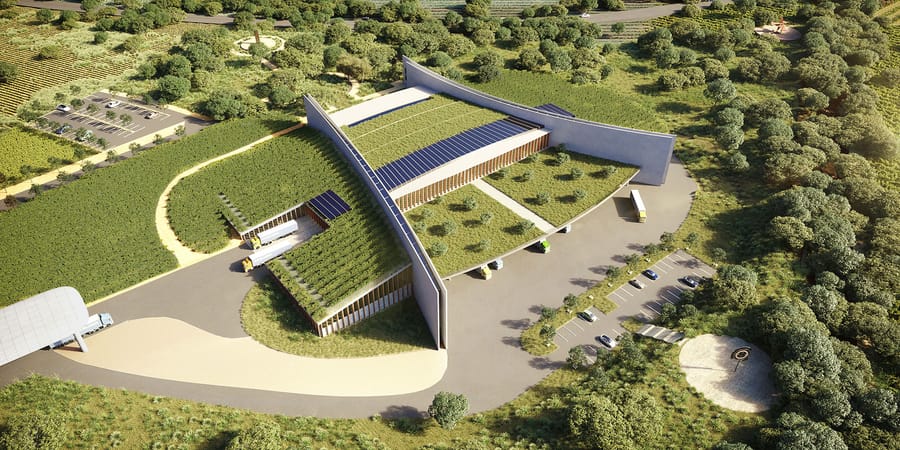 Vue aérienne d'un bâtiment moderne aux toits végétalisés et panneaux solaires, entouré de végétation et de vignes
