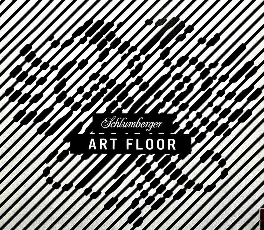 Motif graphique noir et blanc composé de lignes diagonales intégrant l'inscription Schlumberger ART FLOOR en son centre, en Autriche