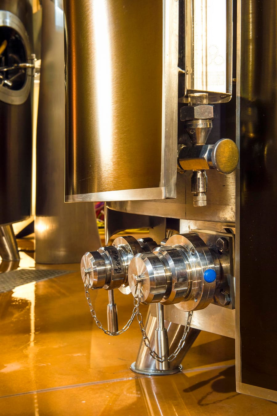 Détail des vannes et raccords en inox d'une cuve de vinification dans un cuvier moderne, Château d'Yquem à Sauternes