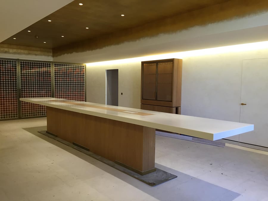 Long comptoir de dégustation en bois avec plateau blanc et éclairage intégré dans une salle aménagée, Château d'Yquem à Sauternes