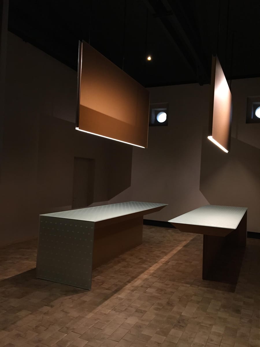 Tables de dégustation minimalistes éclairées par des suspensions rectangulaires dans un espace architectural contemporain, Château d'Yquem à Sauternes
